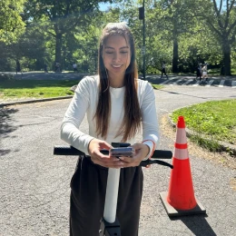 Rider checking directions on her phone on an e-scooter