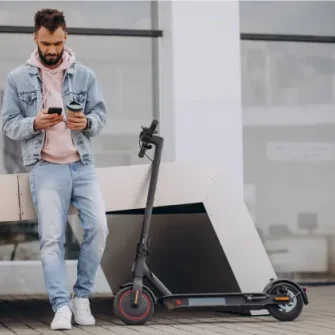 Rider checking the Ride by iPakket app beside a parked e-scooter