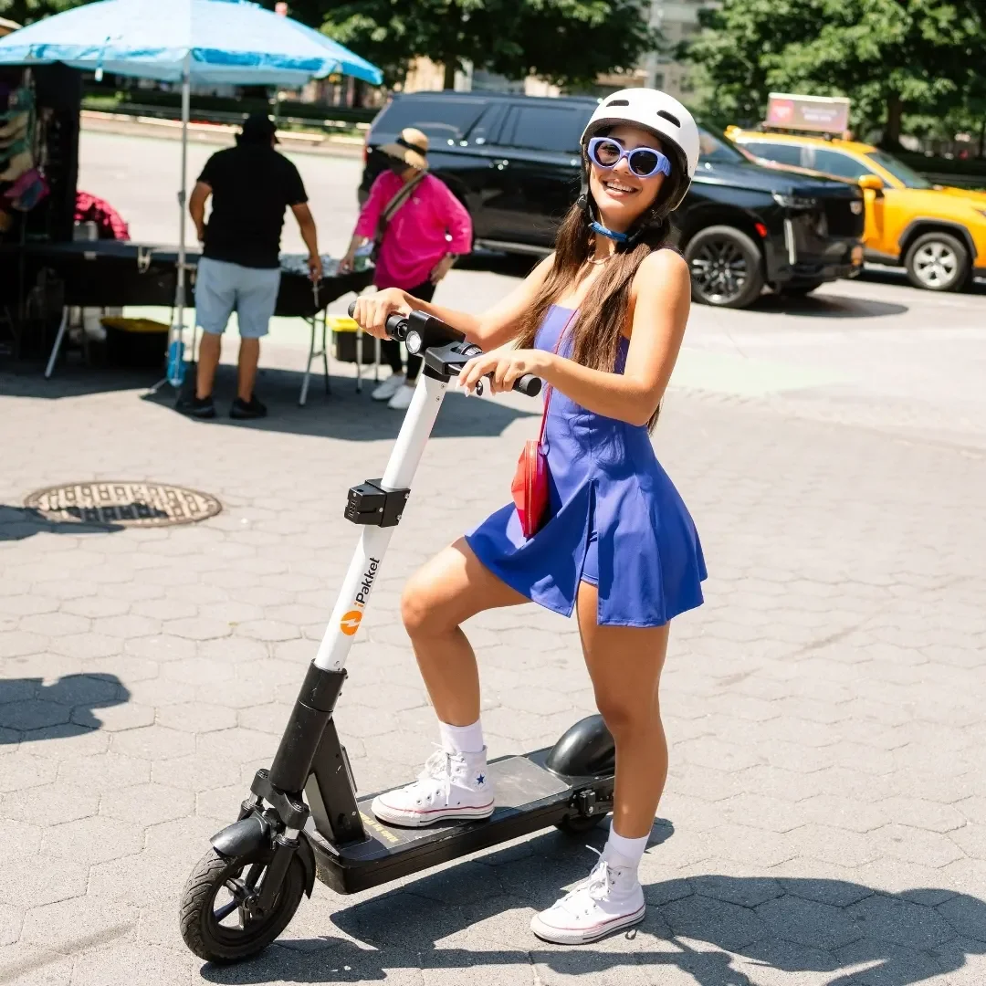 Rider with a Ride by iPakket e-scooter at an urban street market