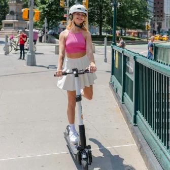 Rider on a Ride by iPakket e-scooter beside a transit station entrance